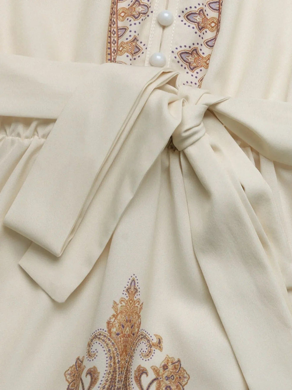 Daphné – Robe courte beige imprimée à manches longues avec ceinture élégante à nouer