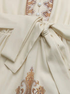 Daphné – Robe courte beige imprimée à manches longues avec ceinture élégante à nouer
